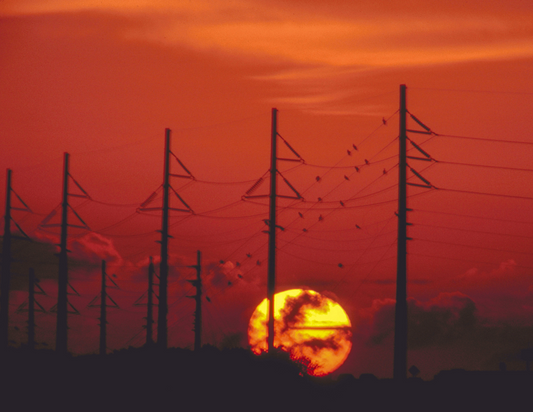 Sunset with power poles and power lines. 